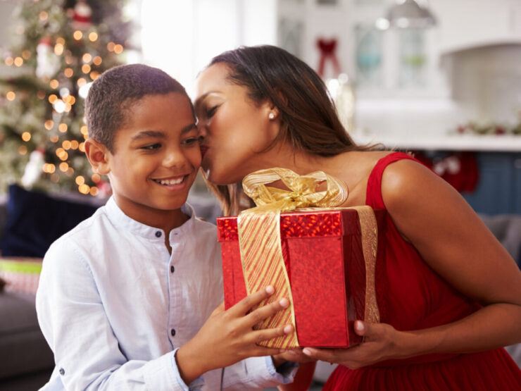 Mother Giving Christmas Presents To Son At Home