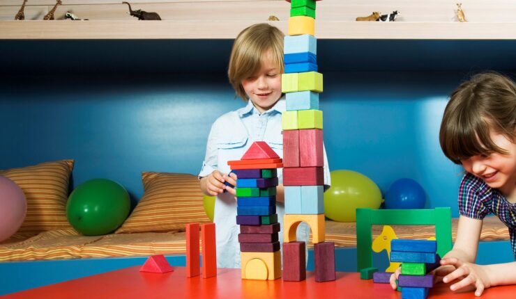 Image: Boy and gir at table playing with building blocks, smiling